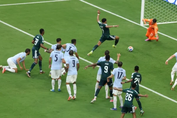 Saudi Arabia and Uruguay players crowding the penalty box during a goal-mouth scramble at FIFA World Cup 2026, with goalkeeper diving to make a save
